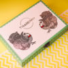 A beautiful box containing sachets of Tia & Berry Tea Bags placed on a yellow and white surface.